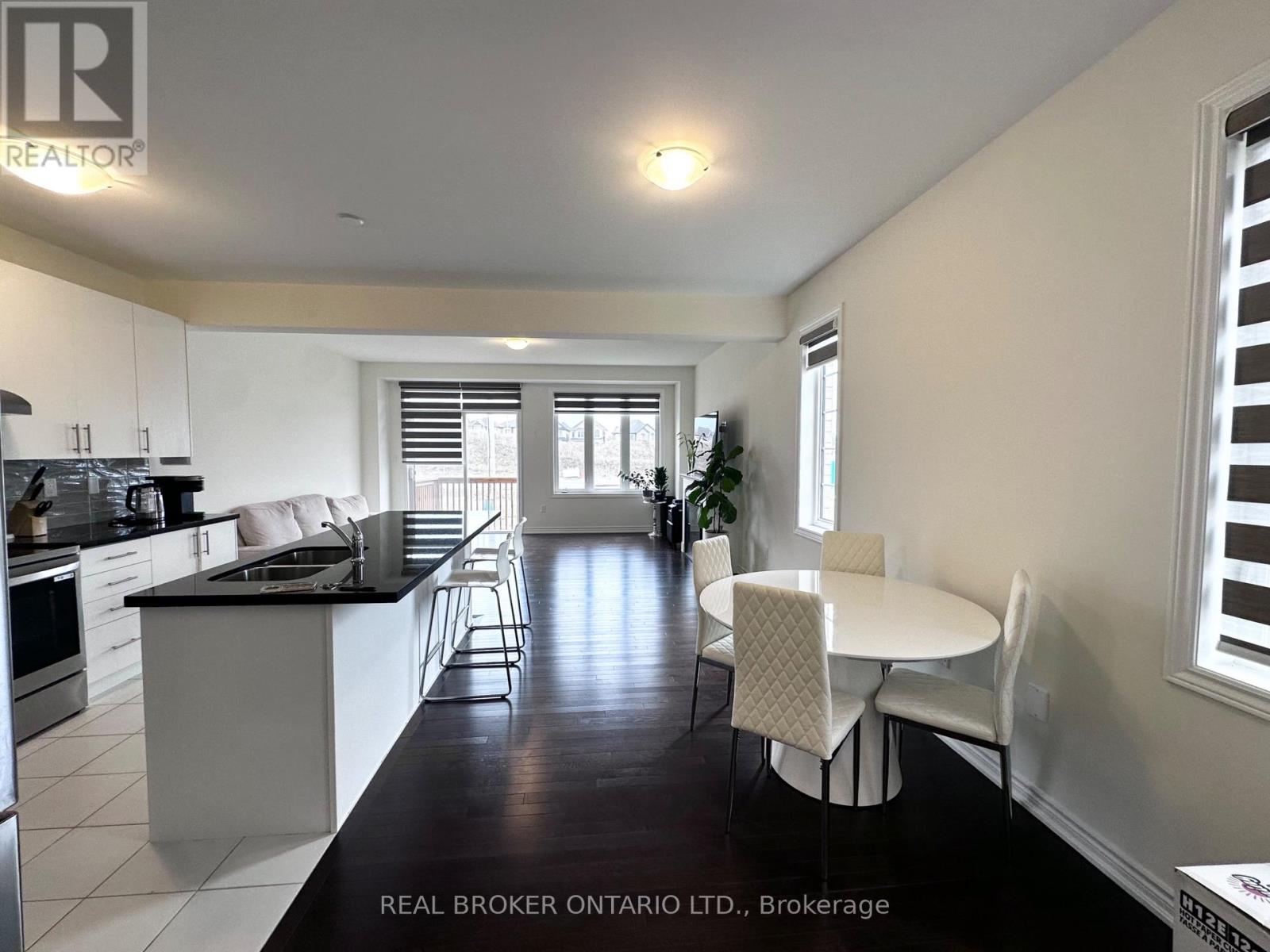 A modern kitchen with white cabinets and black countertops.