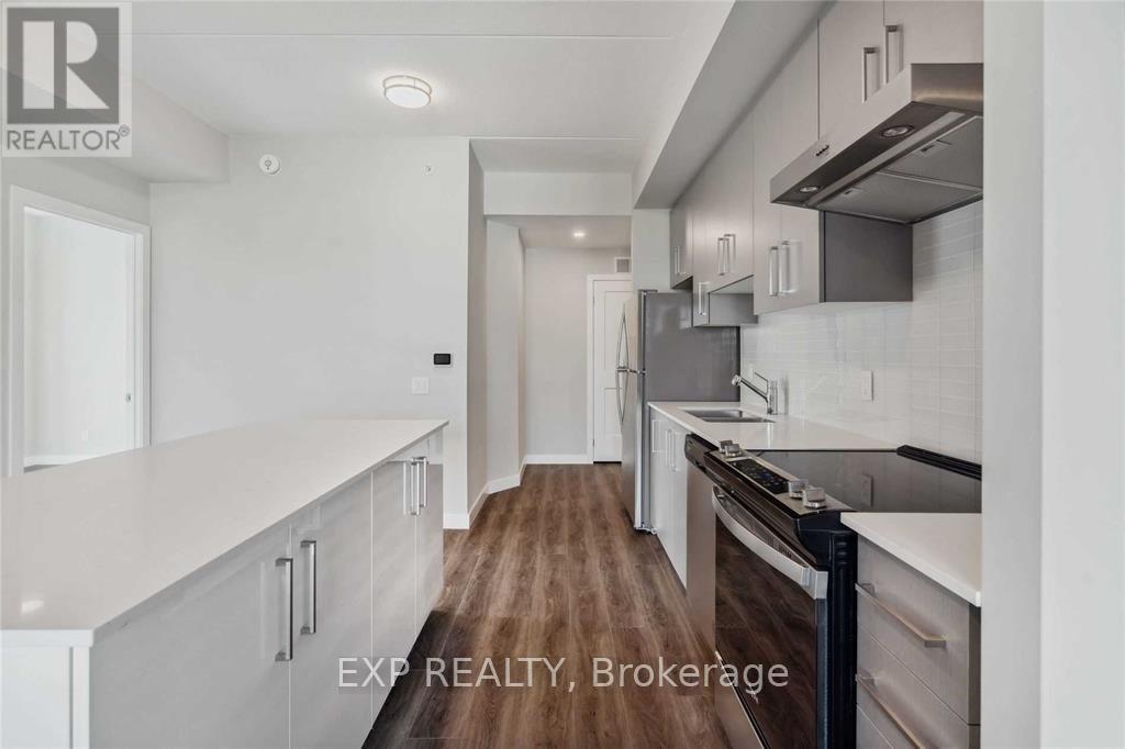 A modern kitchen with white cabinets and a wooden floor.