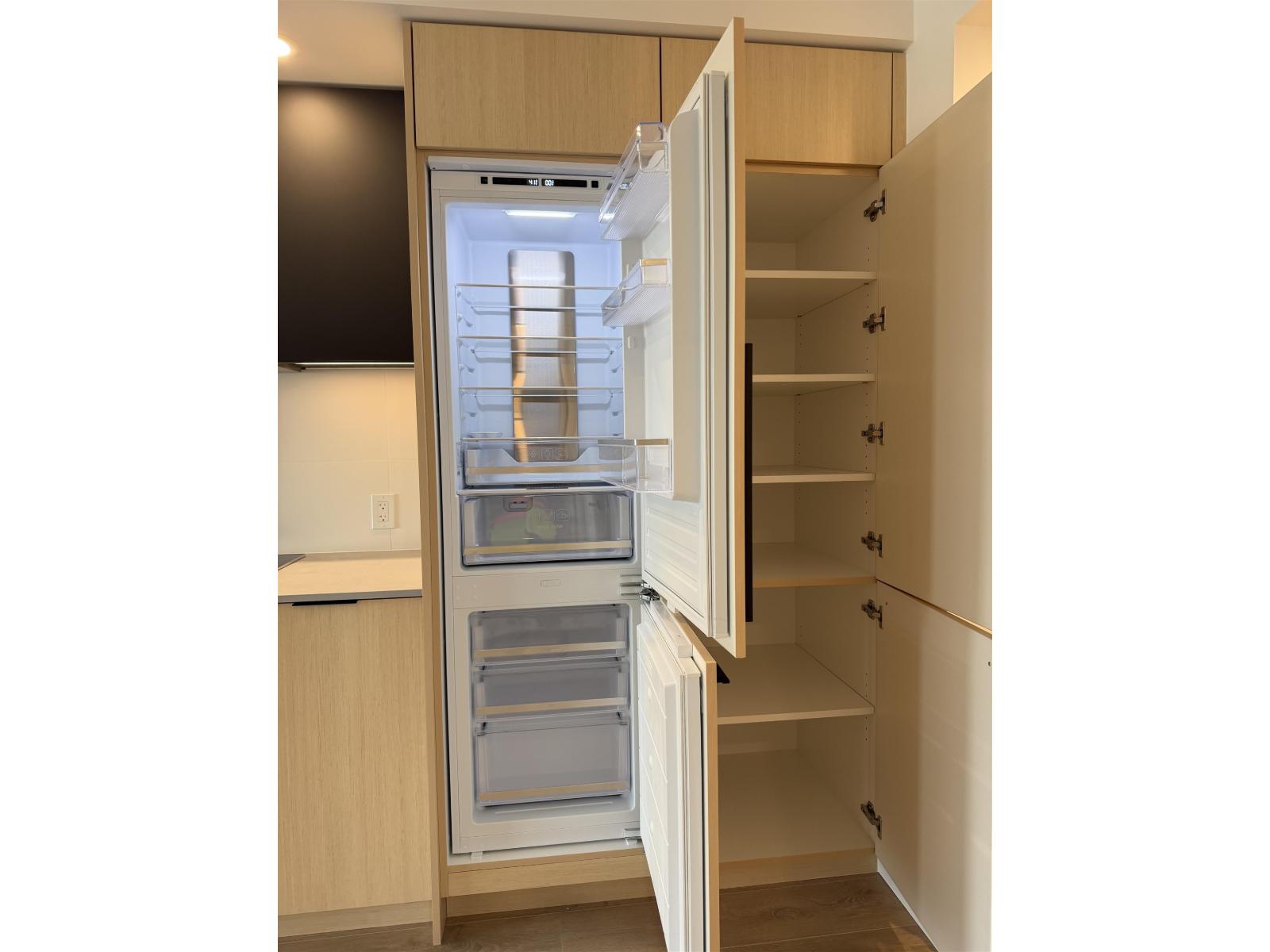 A kitchen with a refrigerator and cabinets.
