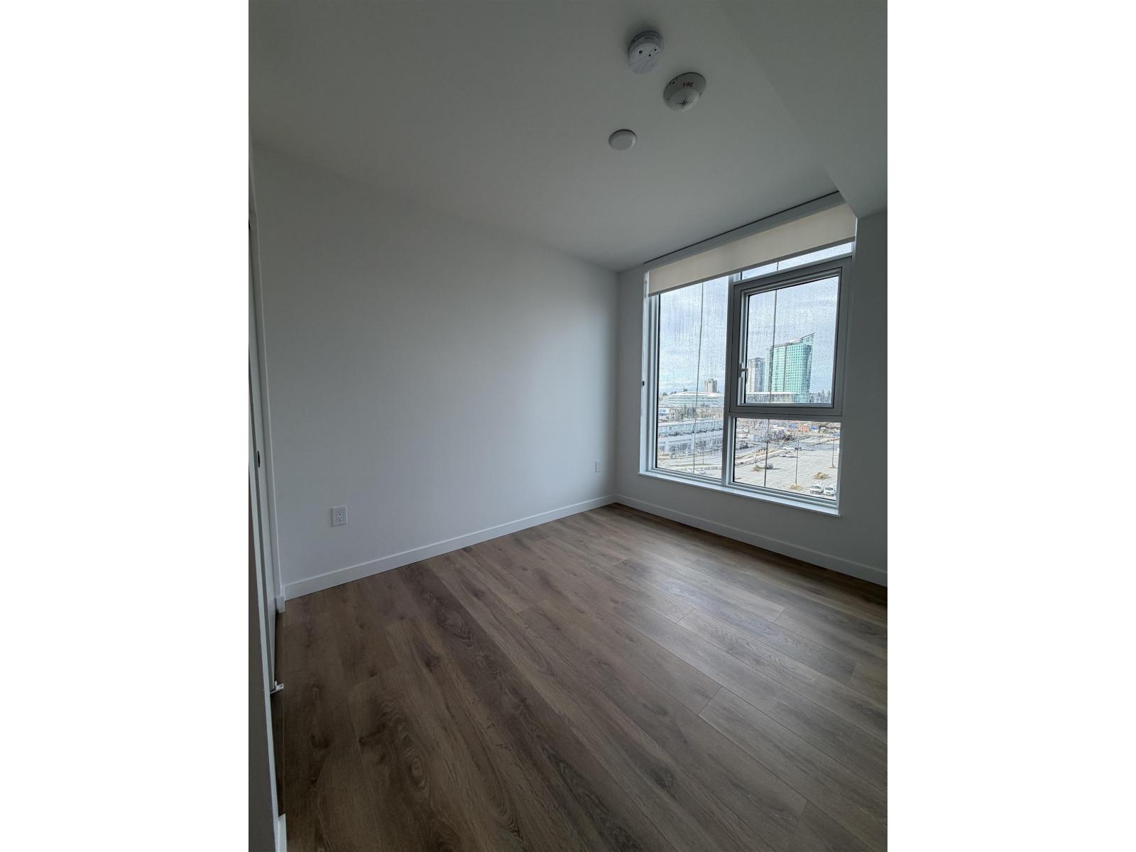 A room with a window and wooden flooring.