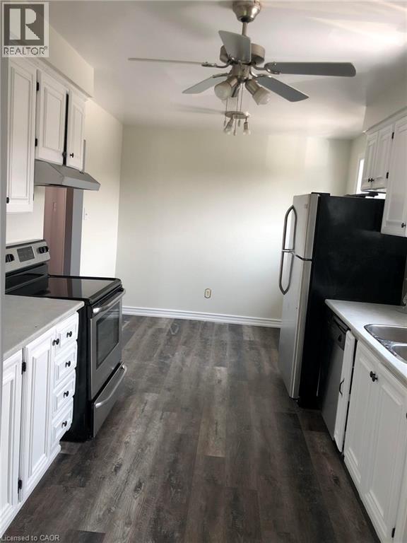A kitchen with black appliances and white cabinets.