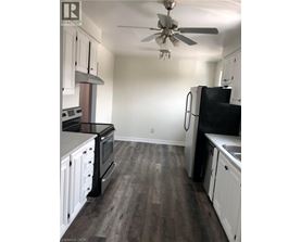 A kitchen with black appliances and white cabinets.
