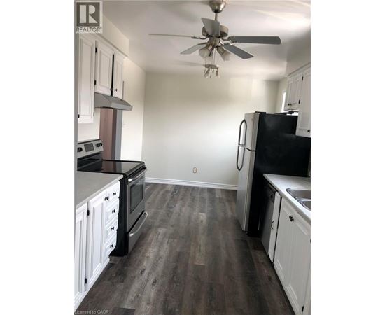 A kitchen with black appliances and white cabinets.