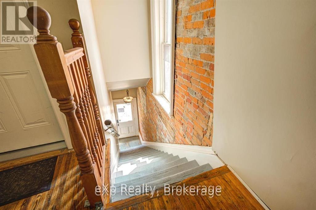 A staircase with a wooden banister leads to a door.