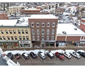 A parking lot with cars and a building with a sign that says "eXp Realty, Brokerage".