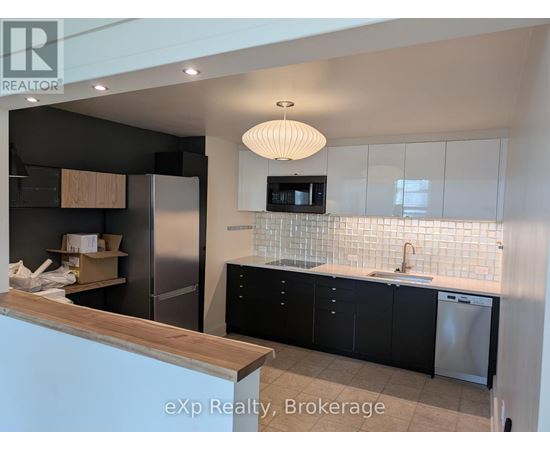 A kitchen with black cabinets and a wooden counter.