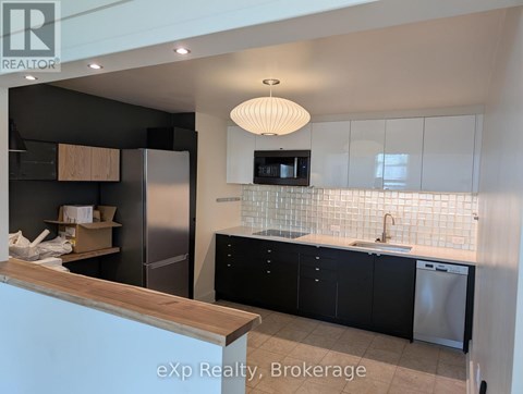 A kitchen with black cabinets and a wooden counter.