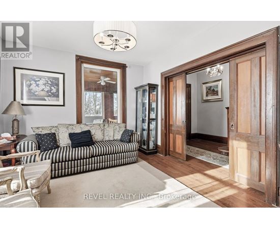 A living room with a striped couch and a wooden cabinet.