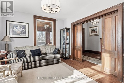 A living room with a striped couch and a wooden cabinet.