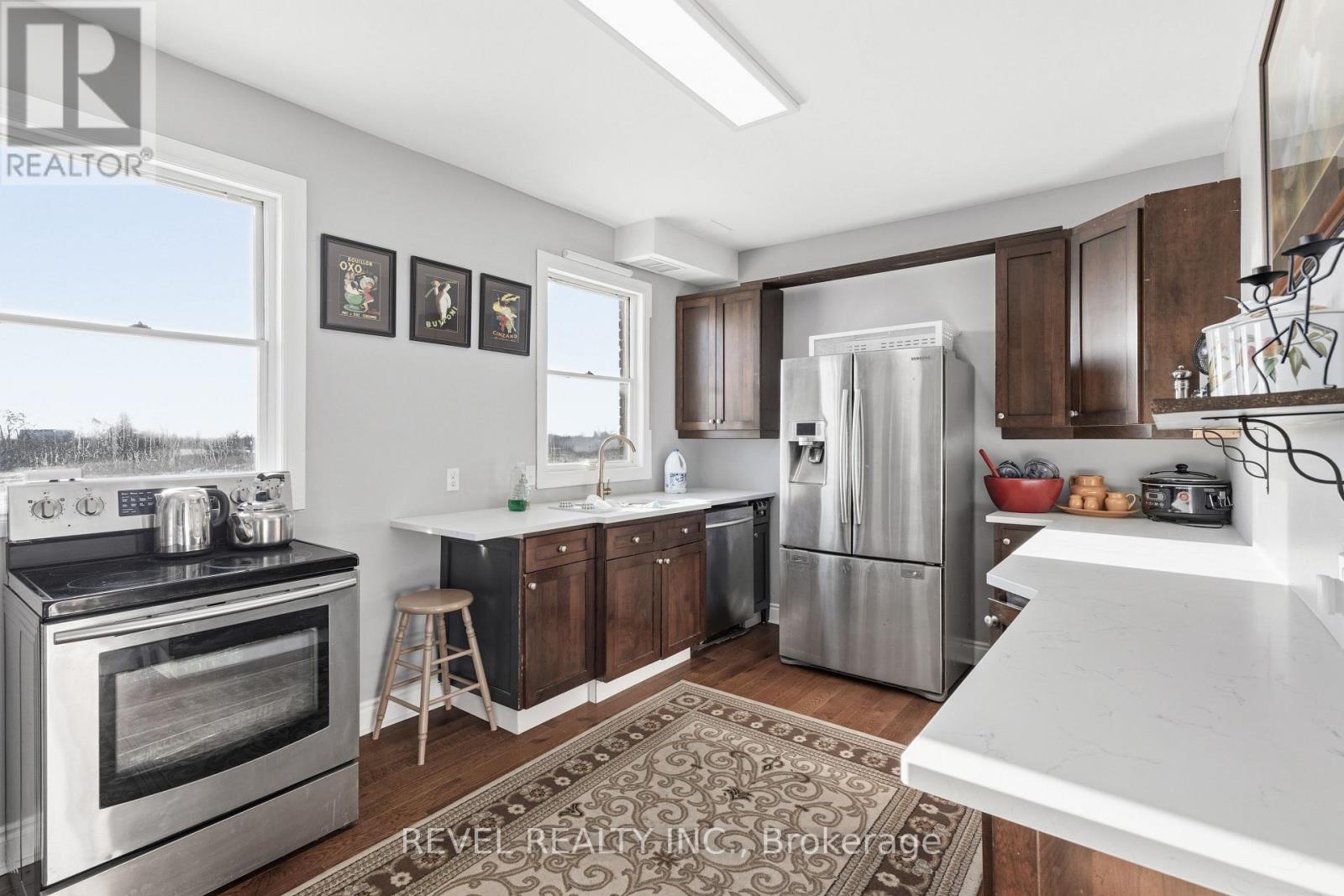 A kitchen with a stove top oven, refrigerator, and cabinets.