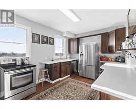 A kitchen with a stove top oven, refrigerator, and cabinets.