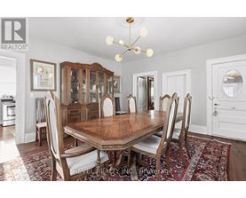 A dining room with a wooden table and chairs.
