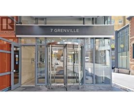 The entrance to a building with a glass door and a sign that reads "7 Grenville".