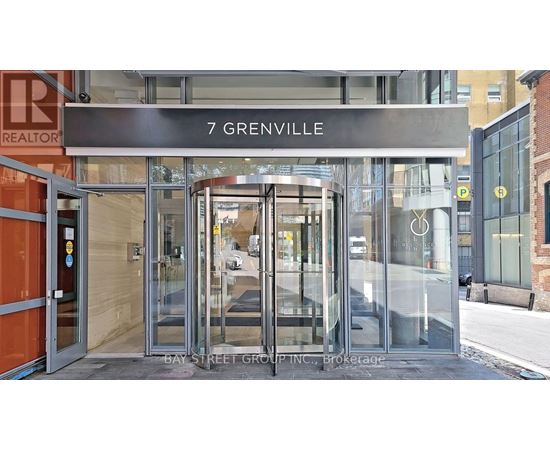 The entrance to a building with a glass door and a sign that reads "7 Grenville".
