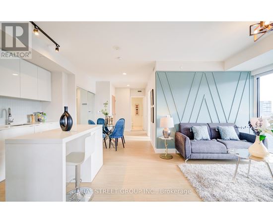 A modern living room with a kitchen area in the background.