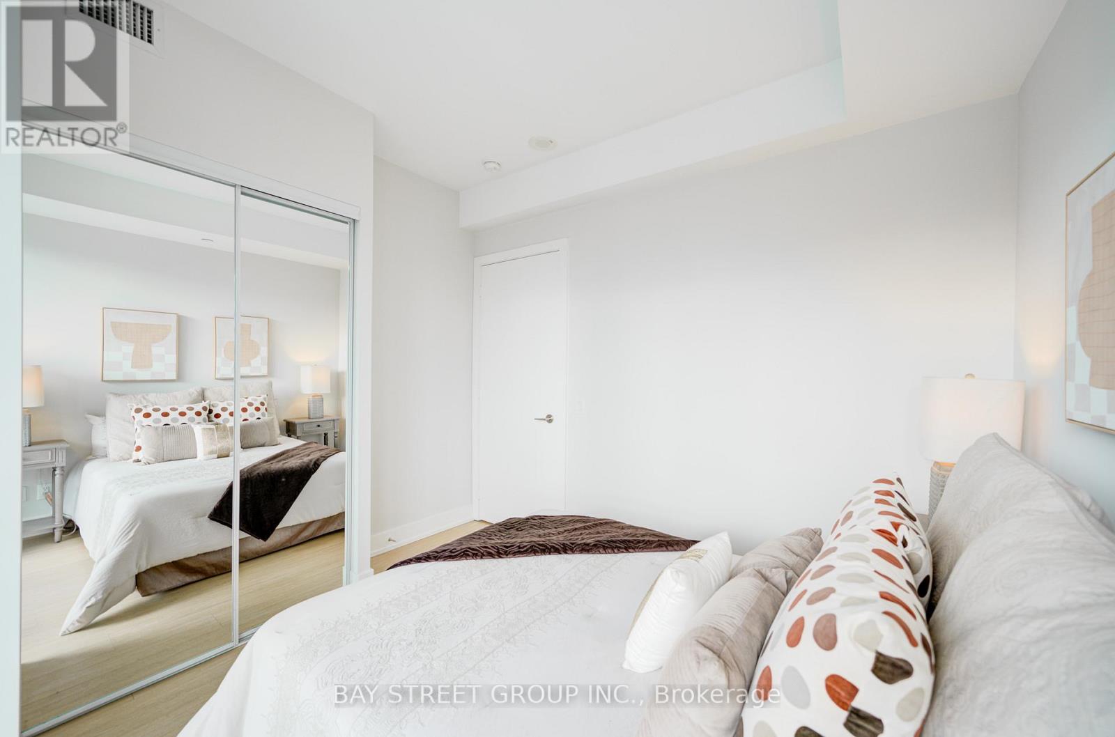 A bedroom with a large bed and a mirror on the wall.