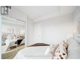 A bedroom with a large bed and a mirror on the wall.