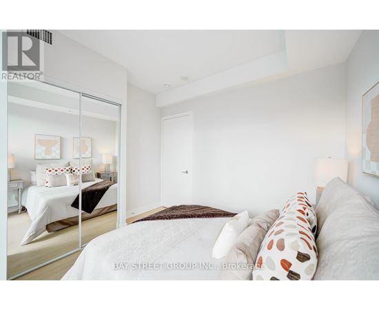 A bedroom with a large bed and a mirror on the wall.