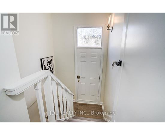 A white door is in a white room.