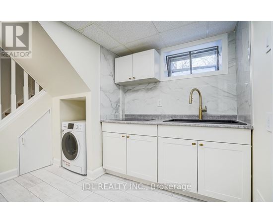 A white kitchen with a washer and dryer built in.