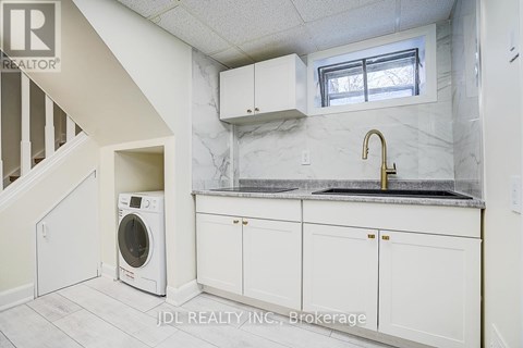 A white kitchen with a washer and dryer built in.