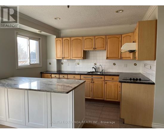 A kitchen with wooden cabinets and a marble countertop.