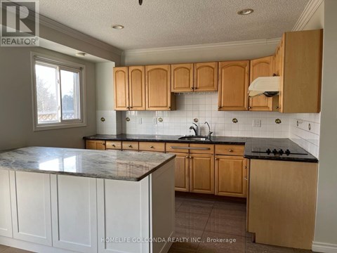 A kitchen with wooden cabinets and a marble countertop.