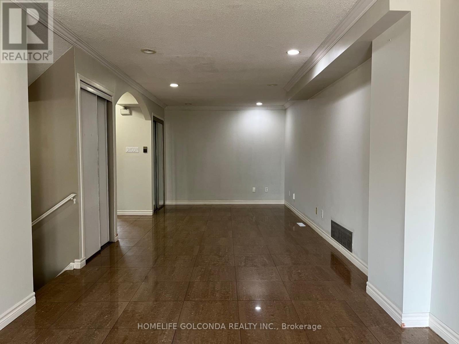 A spacious room with a door on the left and a wall heater on the right.