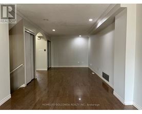 A spacious room with a door on the left and a wall heater on the right.
