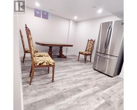 A dining room with a wooden table and chairs.