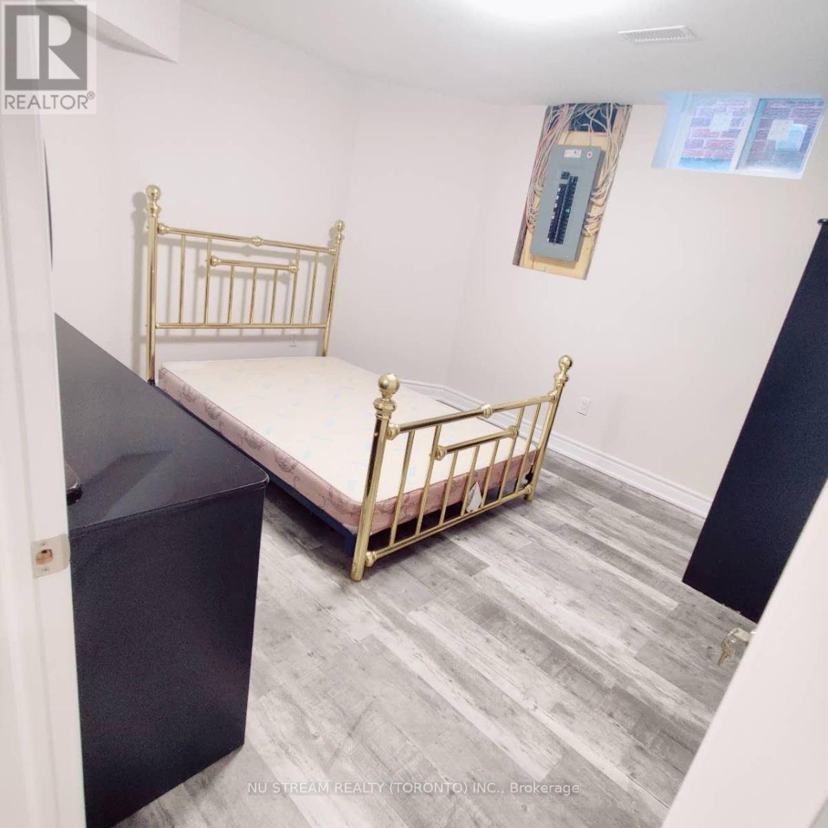 A bedroom with a bed, dresser, and a mirror on the wall.