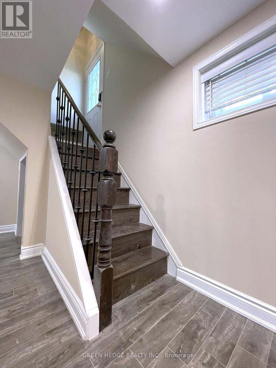 A staircase with a wooden handrail and a window.