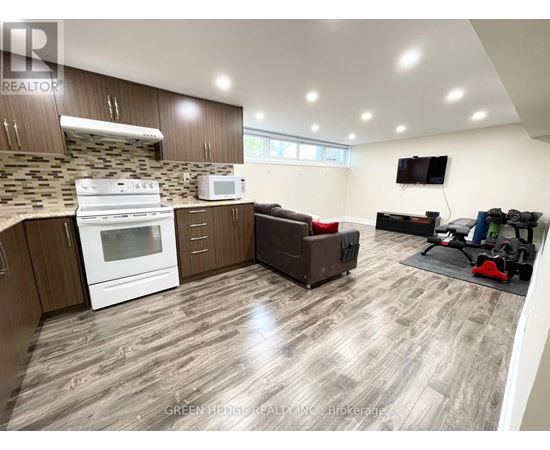 A well-lit kitchen with a white stove and microwave, wooden cabinets, and a grey floor.