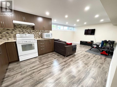 A well-lit kitchen with a white stove and microwave, wooden cabinets, and a grey floor.