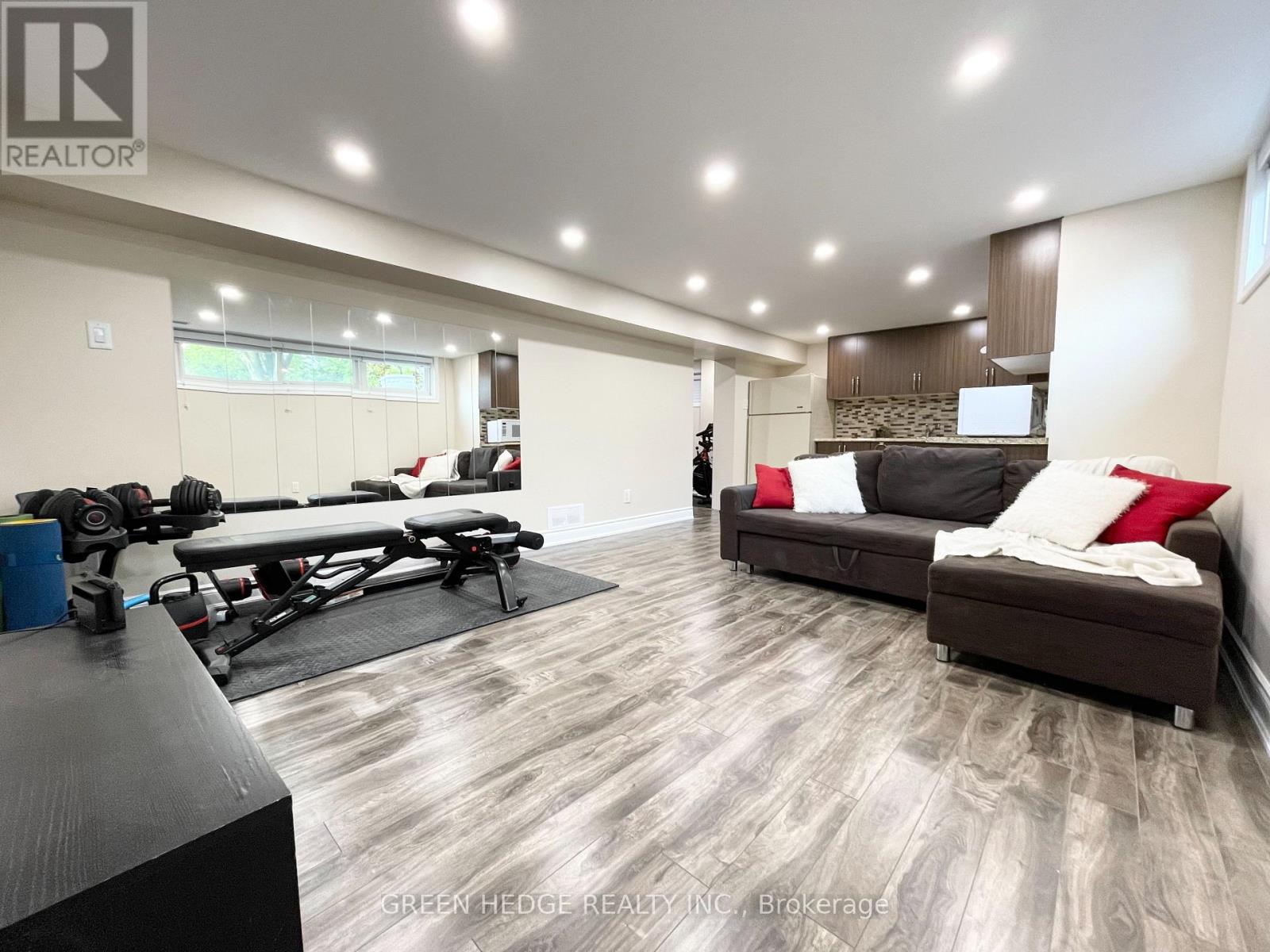A spacious living room with a gym setup in the corner.