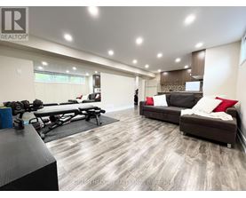 A spacious living room with a gym setup in the corner.