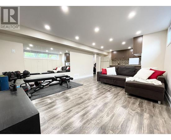 A spacious living room with a gym setup in the corner.