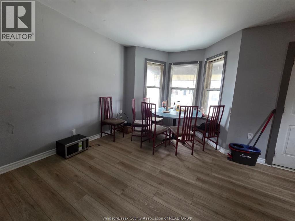 A room with a dining table and chairs.