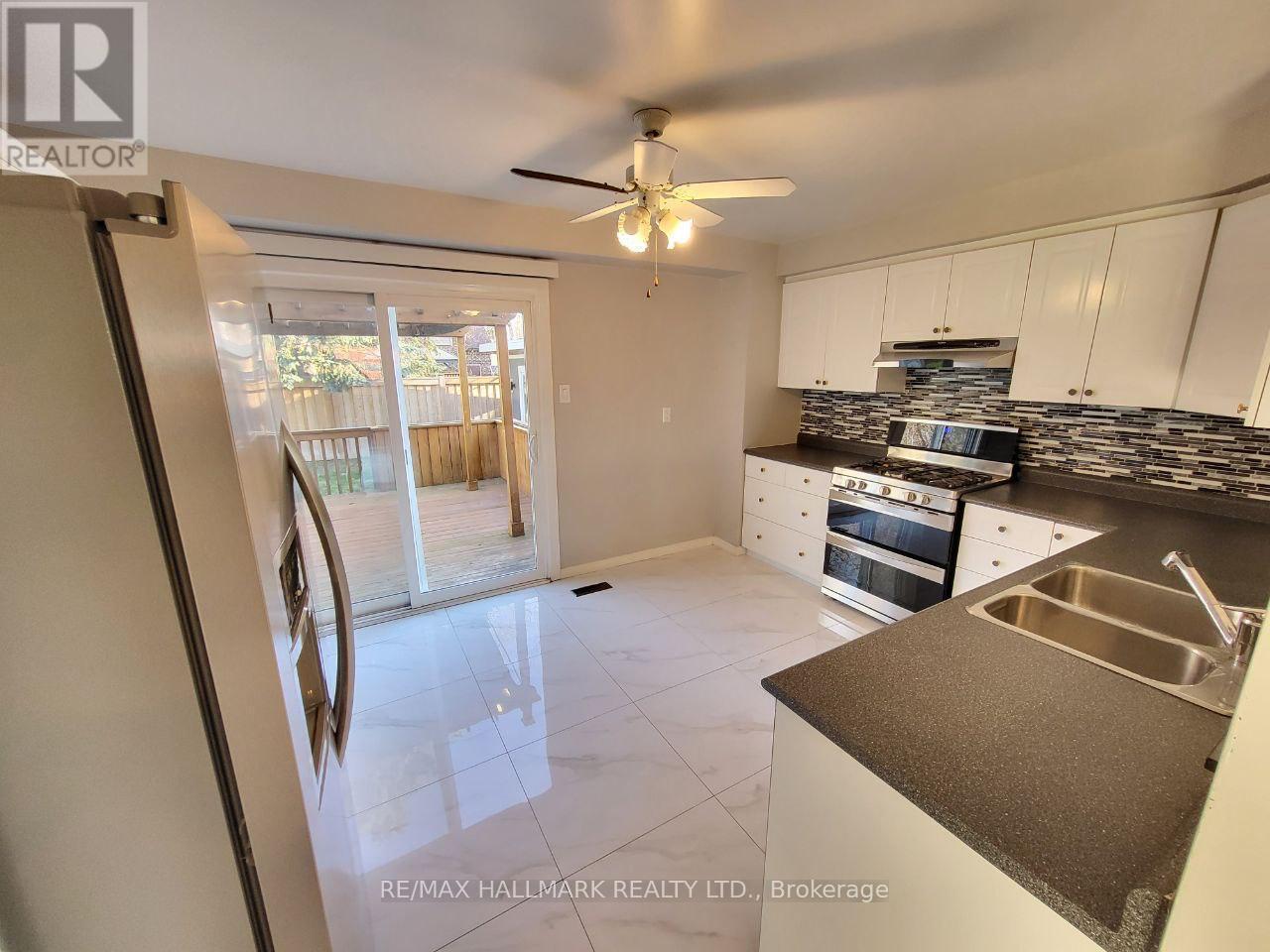 A kitchen with white cabinets and a stainless steel sink.
