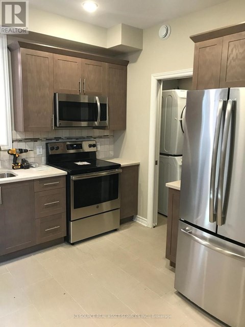 A kitchen with a stainless steel refrigerator and oven.