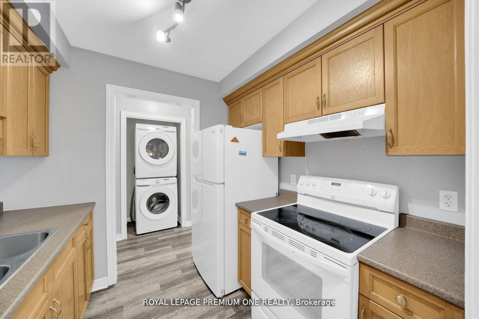 A kitchen with wooden cabinets and a white dishwasher.