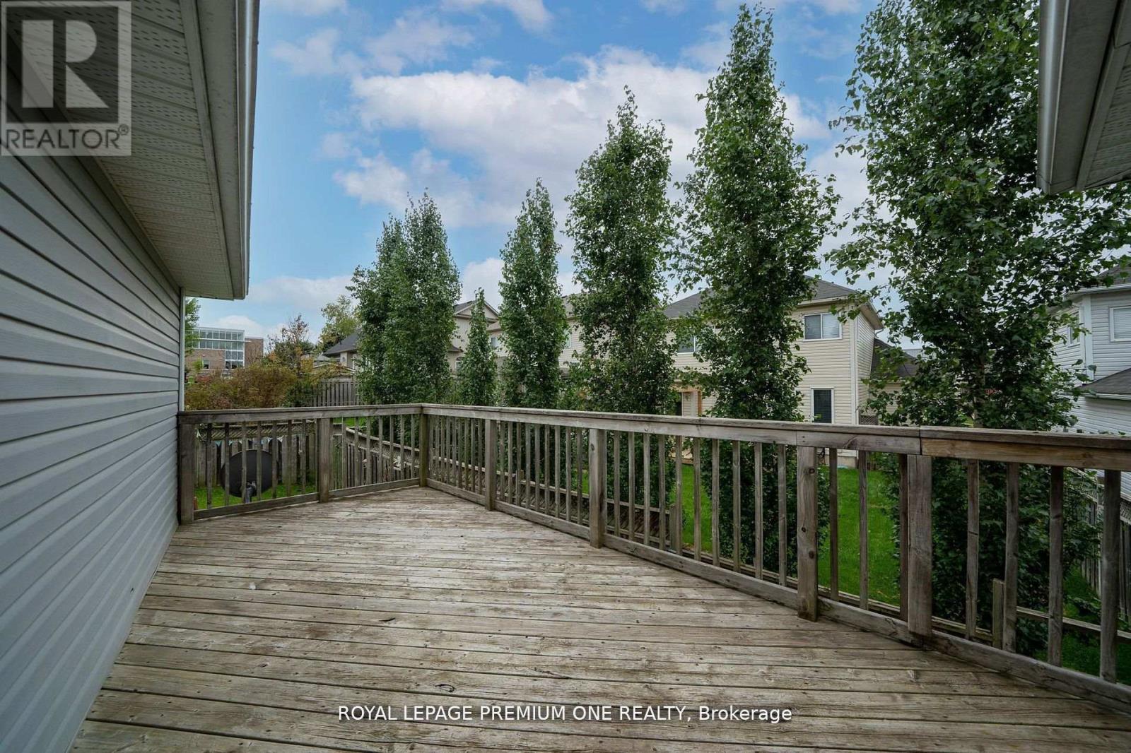 A wooden deck with a railing and trees in the background.