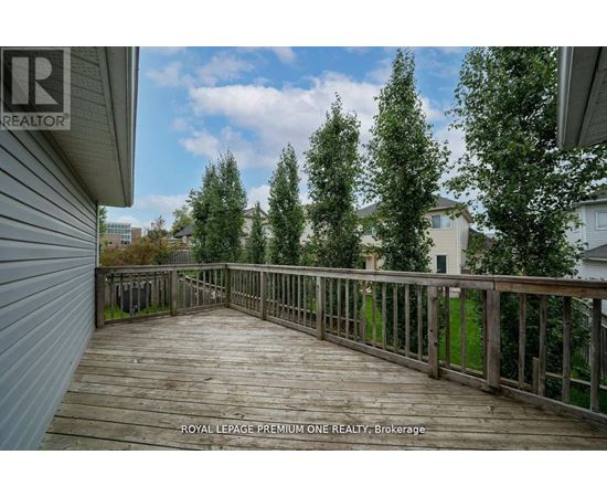 A wooden deck with a railing and trees in the background.