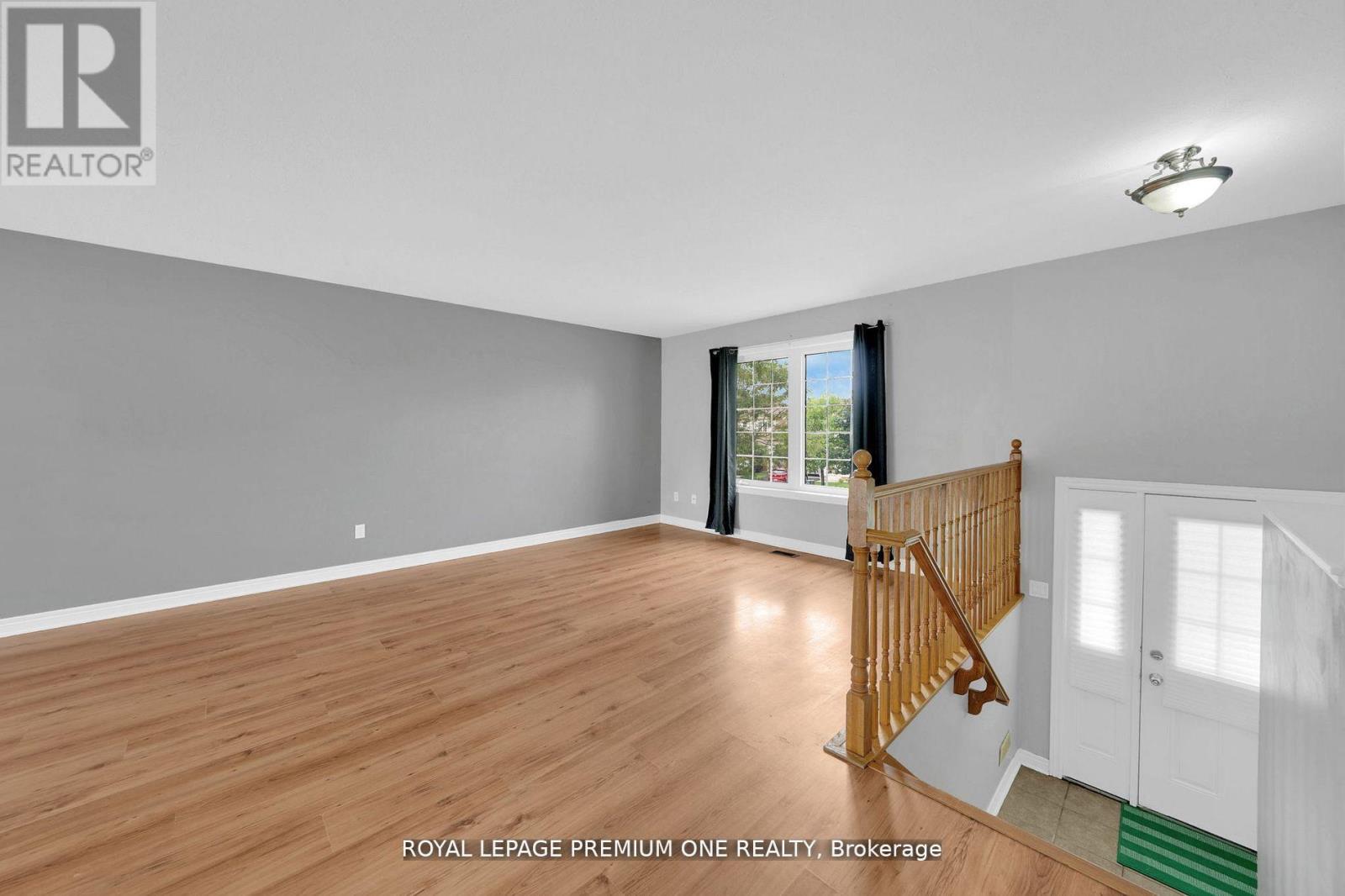 A spacious room with wooden flooring and a white door.