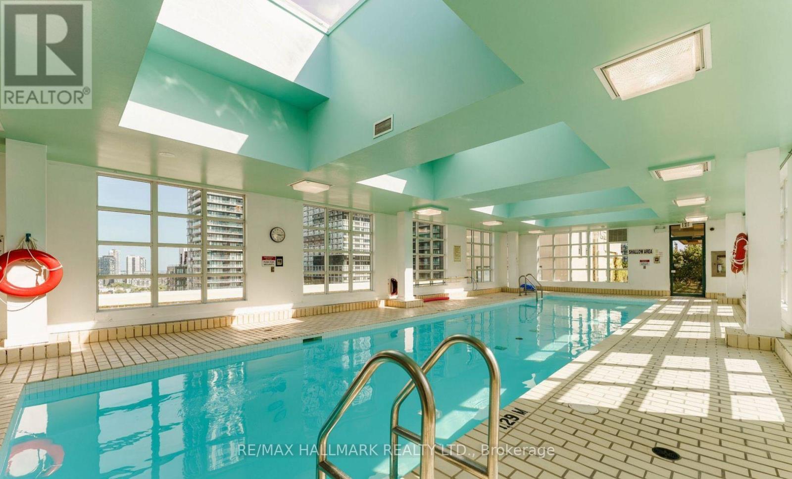 A large indoor swimming pool with a skylight above it.