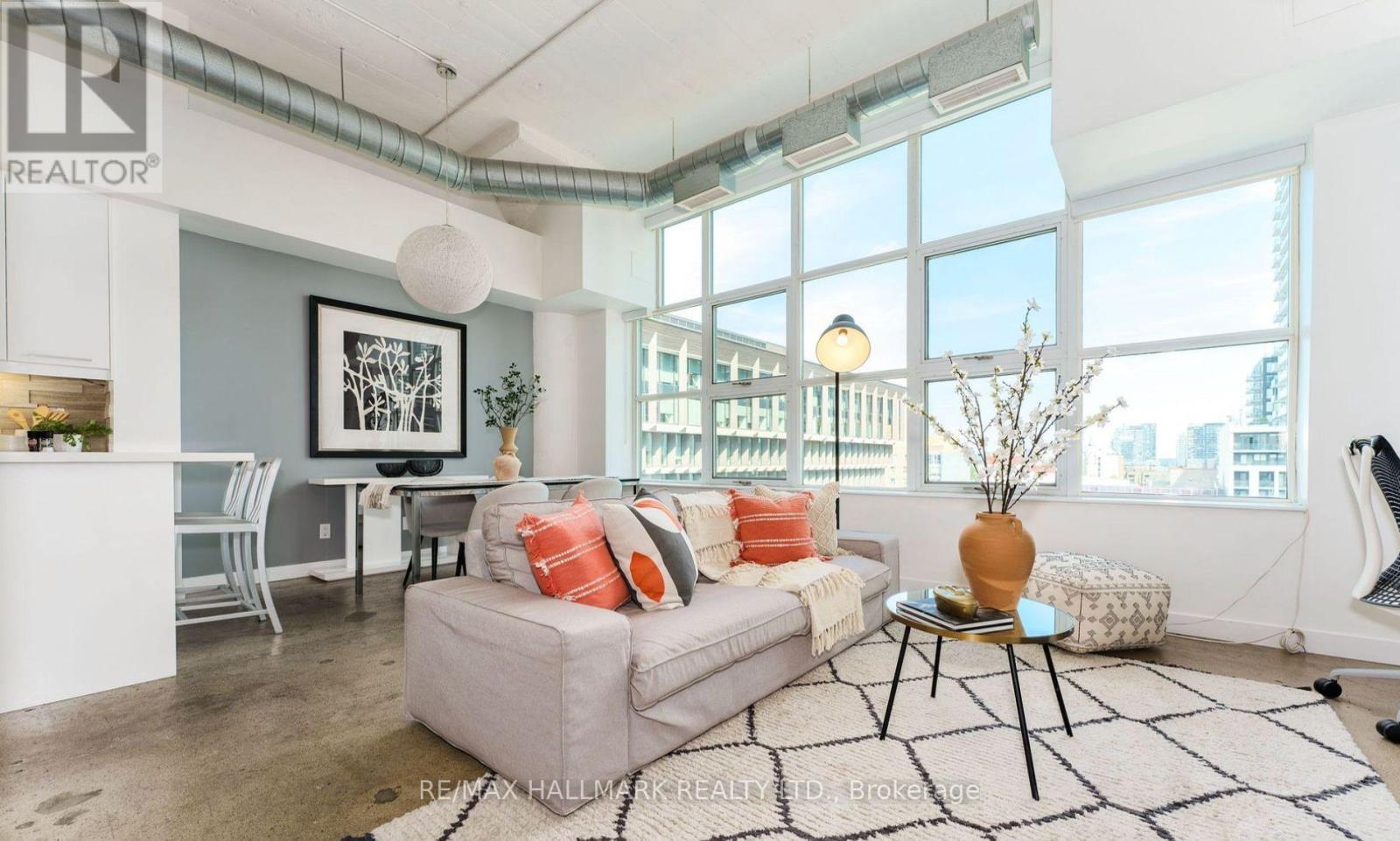 A living room with a grey couch and a black and white rug.