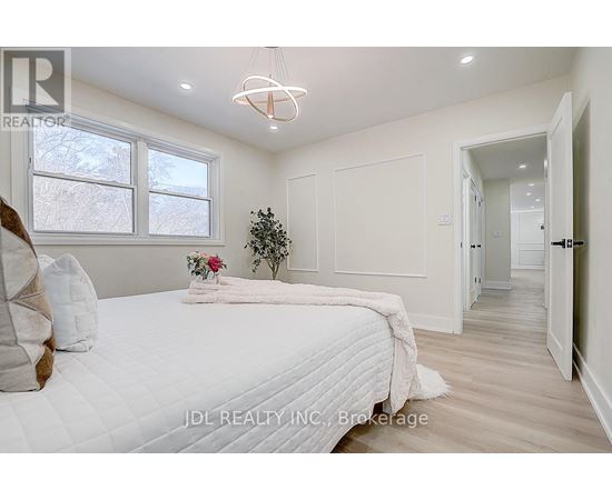 A bedroom with a large bed and a chandelier.