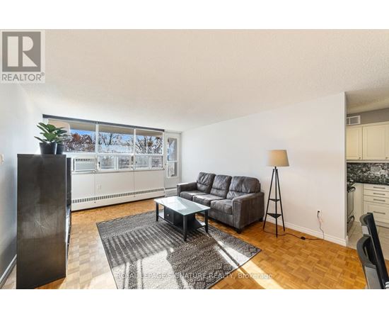 A living room with a grey sofa and a black coffee table.