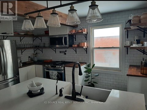 A kitchen with a white counter top and a window.