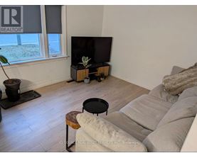 A living room with a couch, a table, and a television.